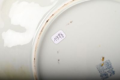 un gros plan d'un vase blanc sur lequel est collé un autocollant