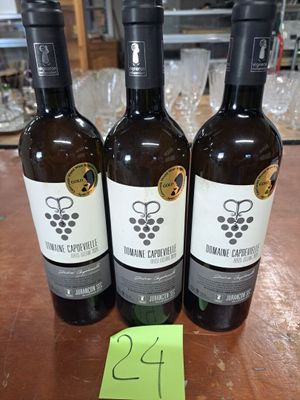 trois bouteilles de vin posées sur une table en bois
