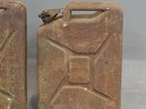 two old jerry cans sitting side by side on a table