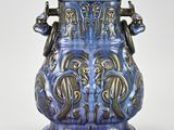 a blue vase that has two handles on it