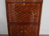 a wooden chest of drawers with a marble top