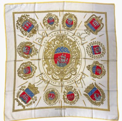 un gros plan sur une écharpe blanche et dorée ornée d'un blason