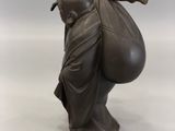 bronze statue of a man carrying a bag on his back