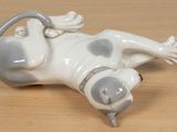 a figurine of a cat laying on its back