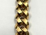 a close up of a gold chain bracelet on a white surface
