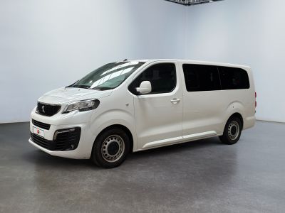 La camionnette blanche est garée dans une grande pièce blanche.
