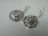 pair of silver plated earrings with a flower design on them