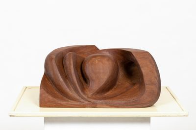 a wooden sculpture on a white pedestal with a white background
