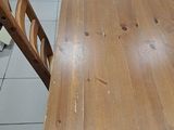 a wooden table and chairs in a room with tile flooring