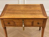 une vieille table en bois surmontée de deux tiroirs