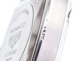 close up of a watch with a silver face and black leather strap