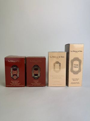 three boxes of perfume sitting next to each other on a white surface