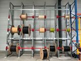 de nombreuses bobines et rouleaux rangés sur un rayonnage dans un entrepôt