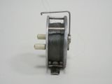 a small metal reel with a handle on a white surface