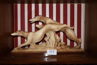 une statue représentant un chien et un chat, dans une boîte en bois