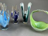 quatre vases en verre de couleurs différentes posés sur une table