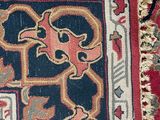 a red and blue rug with a design on it