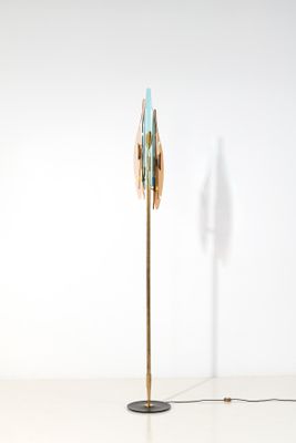 brass floor lamp with a blue glass shade and a black metal base