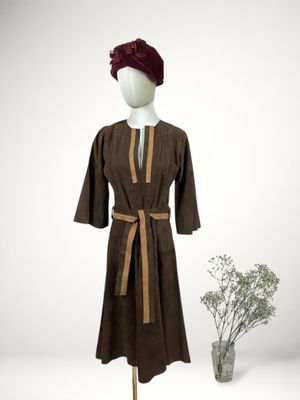 an image of a mannequin wearing a brown robe and a red hat