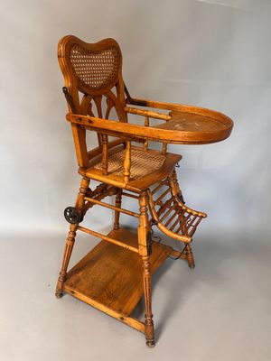 an old wooden high chair with a tray on top of it