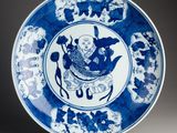 blue and white plate with a bird and flowers design on it