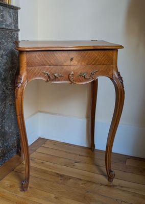 a wooden table with a marble top and a marble fireplace