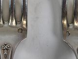 two forks that are sitting side by side on a table