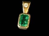 an emerald and diamond pendant on a black background