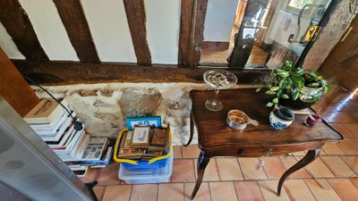 une petite table sur laquelle se trouvent des livres et un verre de vin