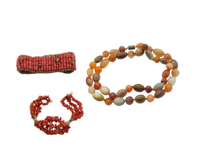 two bracelets and a bead necklace are shown on a white surface