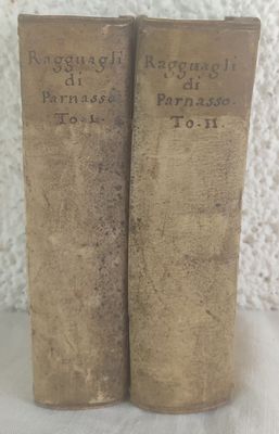 two old books are sitting side by side on a table
