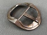 a close up of a metal buckle on a leather surface