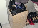 several pairs of shoes are sitting on a wooden box in a closet