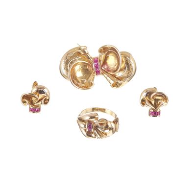 trois bagues en or et une bague ornée de pierres roses sur fond blanc