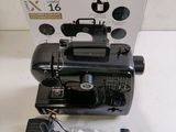 a black sewing machine sitting on a table next to a box