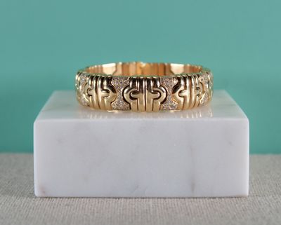 un gros plan d'une bague en or posée sur un bloc de marbre