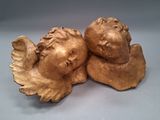 une paire de figurines d'anges en or sur fond blanc