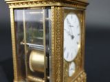 a gold clock sitting on a table with a black background