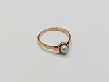 a close up of a gold ring with a pearl on it