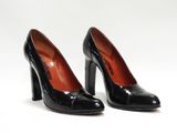 une paire de chaussures noires à talons hauts posée sur une surface blanche