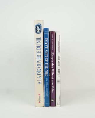 three books are stacked on top of each other on a white surface