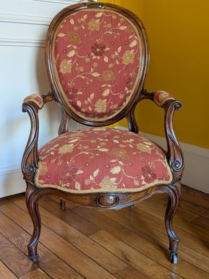 a red and gold chair in a room with a yellow wall