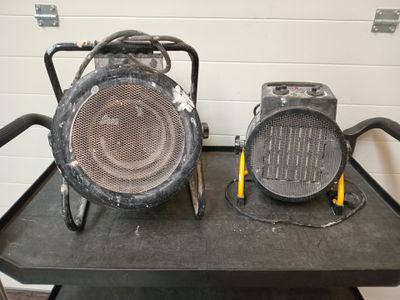deux radiateurs portatifs posés sur un chariot dans un garage