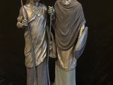 deux statues d'un homme et d'une femme debout l'une à côté de l'autre