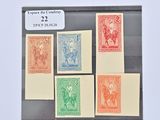 cinq timbres différents dans une vitrine posée sur une table