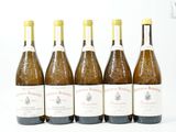 six bouteilles de vin sont alignées sur une surface blanche
