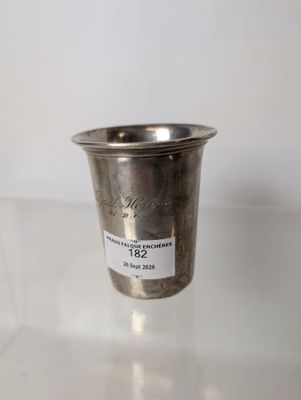 a silver cup sitting on a table with a label on it
