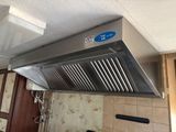 a stainless steel range hood in a kitchen with a blue sticker on it