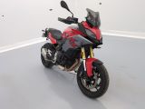 a red and black motorcycle parked in a white room