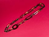 a close up of a pair of brown and black bracelets on a pink background